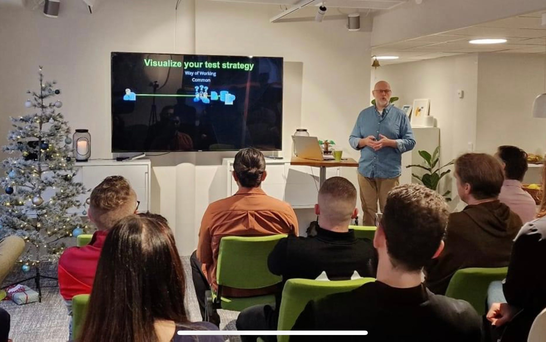 A male person presenting in front of a group of people