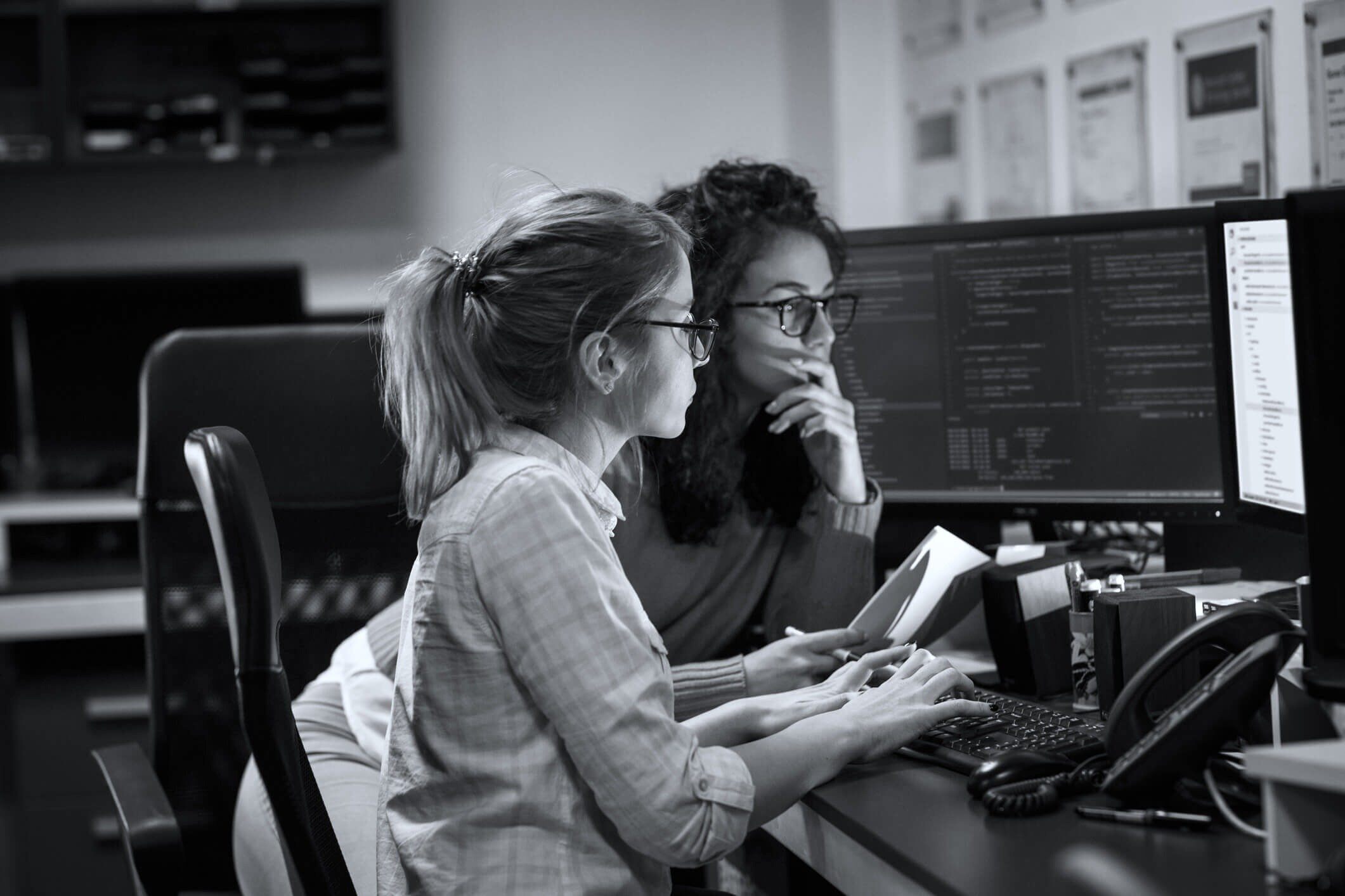 Two-female-programmers-working-on-new-project_They-working-late-at-night-at-the-office_-939787416_2125x1416-1-1