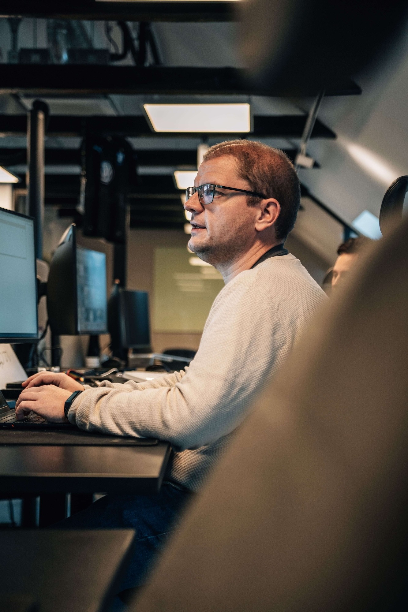 A male cybersecurity expert at his desk in the office