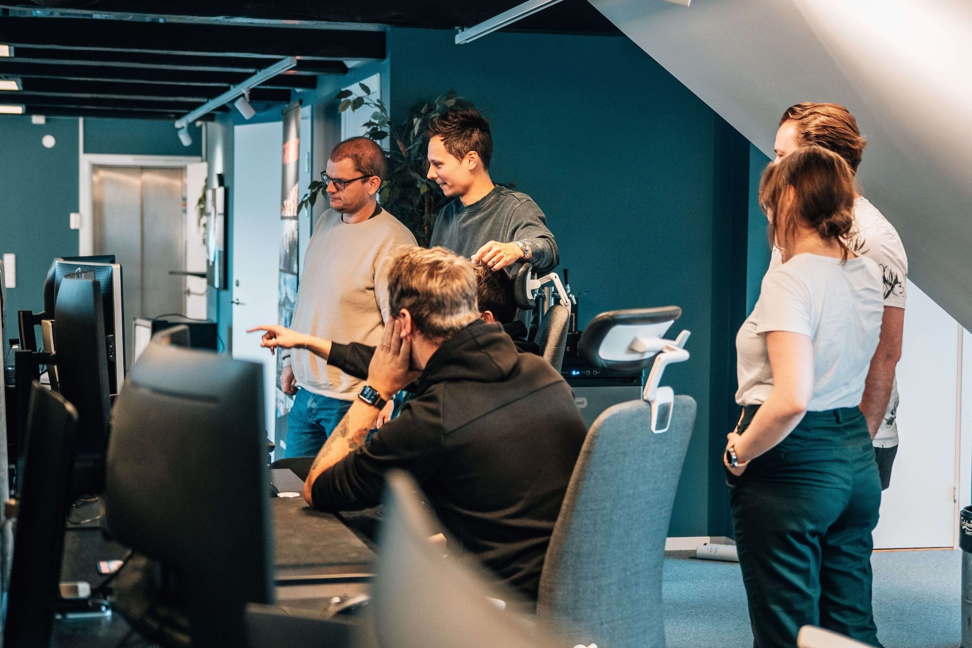 A cybersecurity team standing in front of a desk with a screen