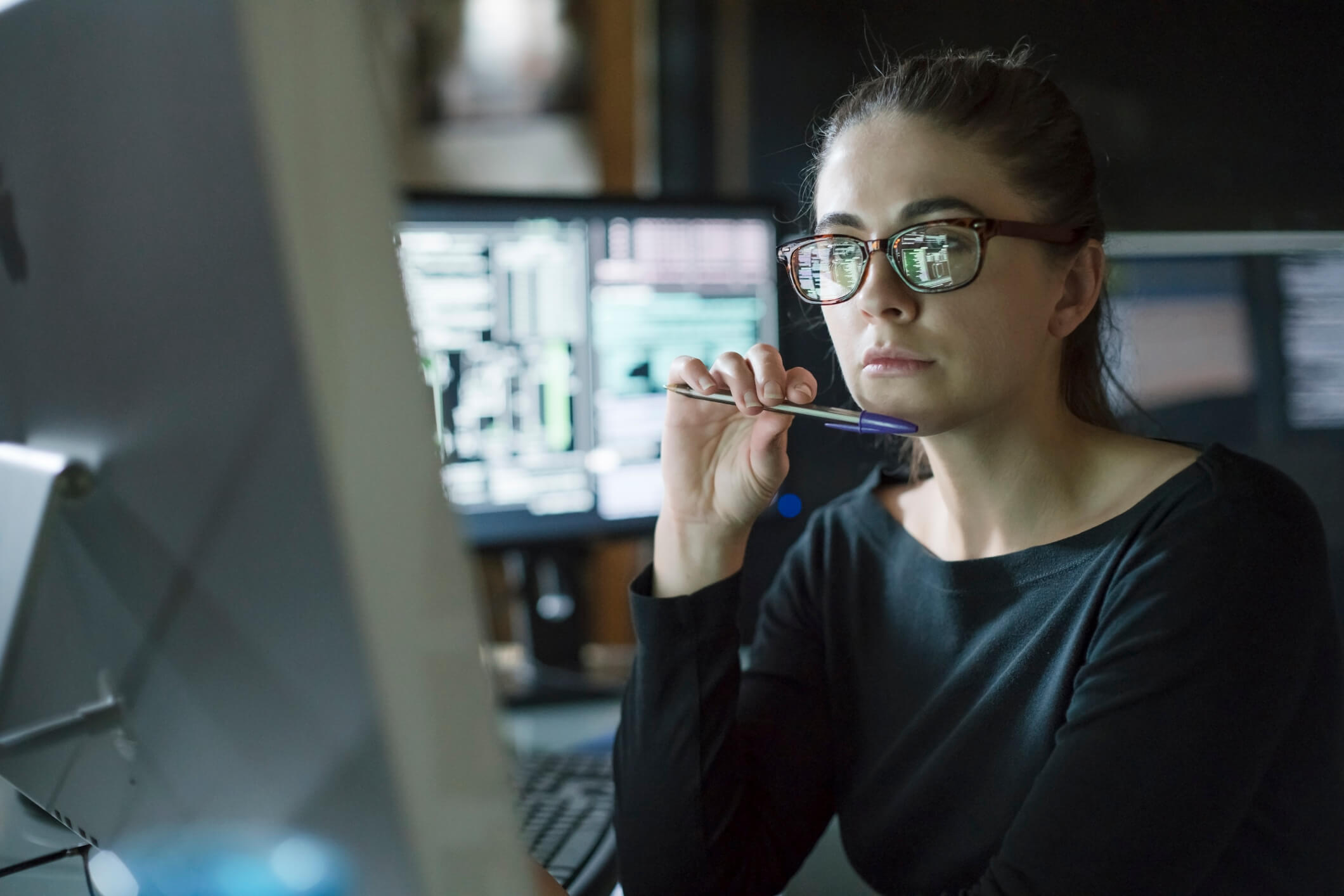 Eine Frau, die vor einem Computer sitzt und denkt