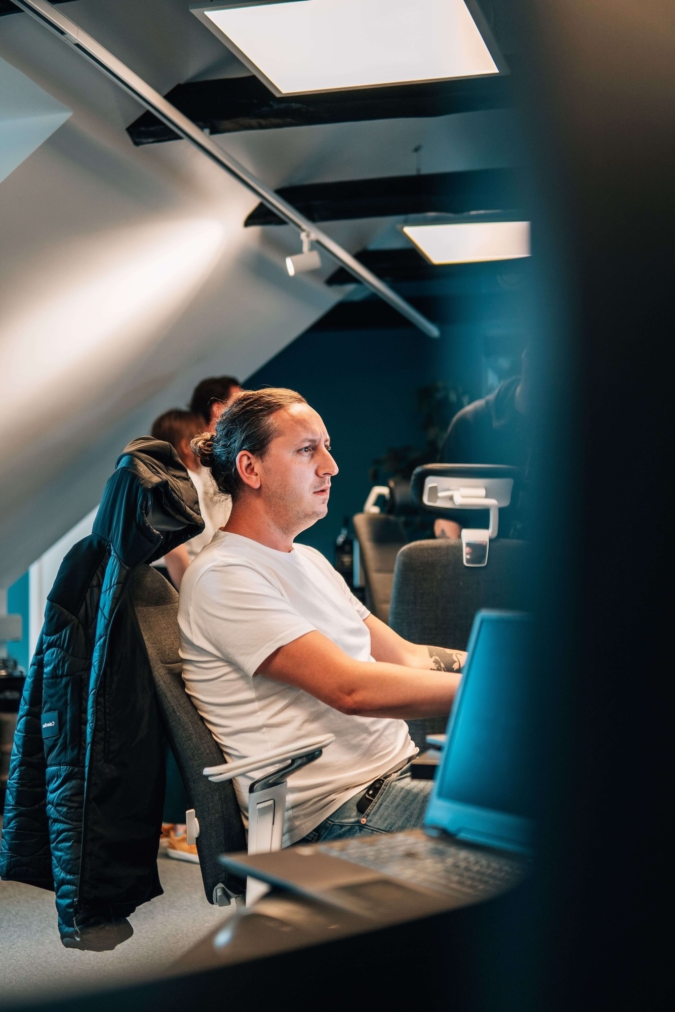 A male person in a chair at a desk in an office