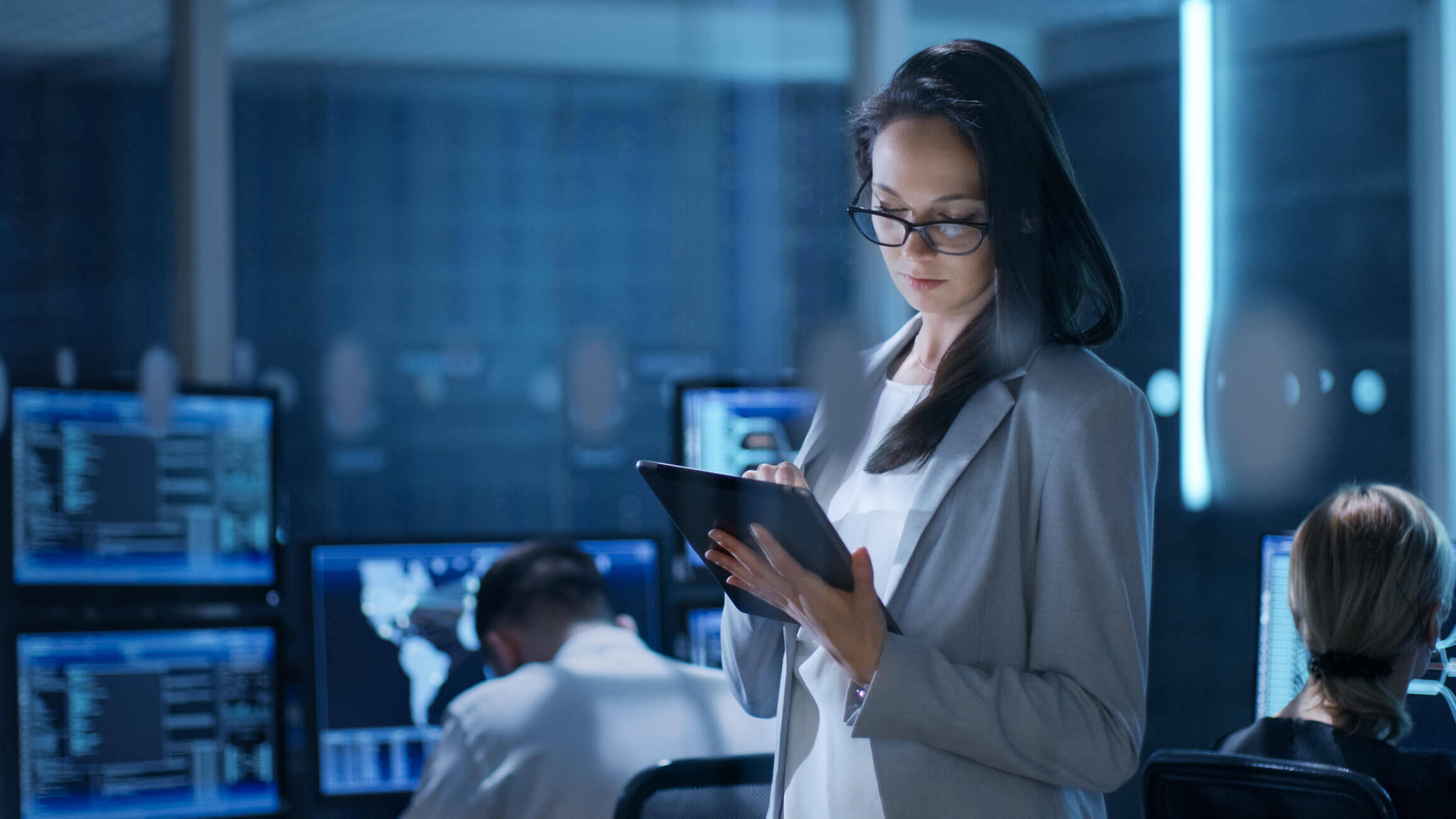 Eine Frau schaut in einer technischen Umgebung auf ein Tablet