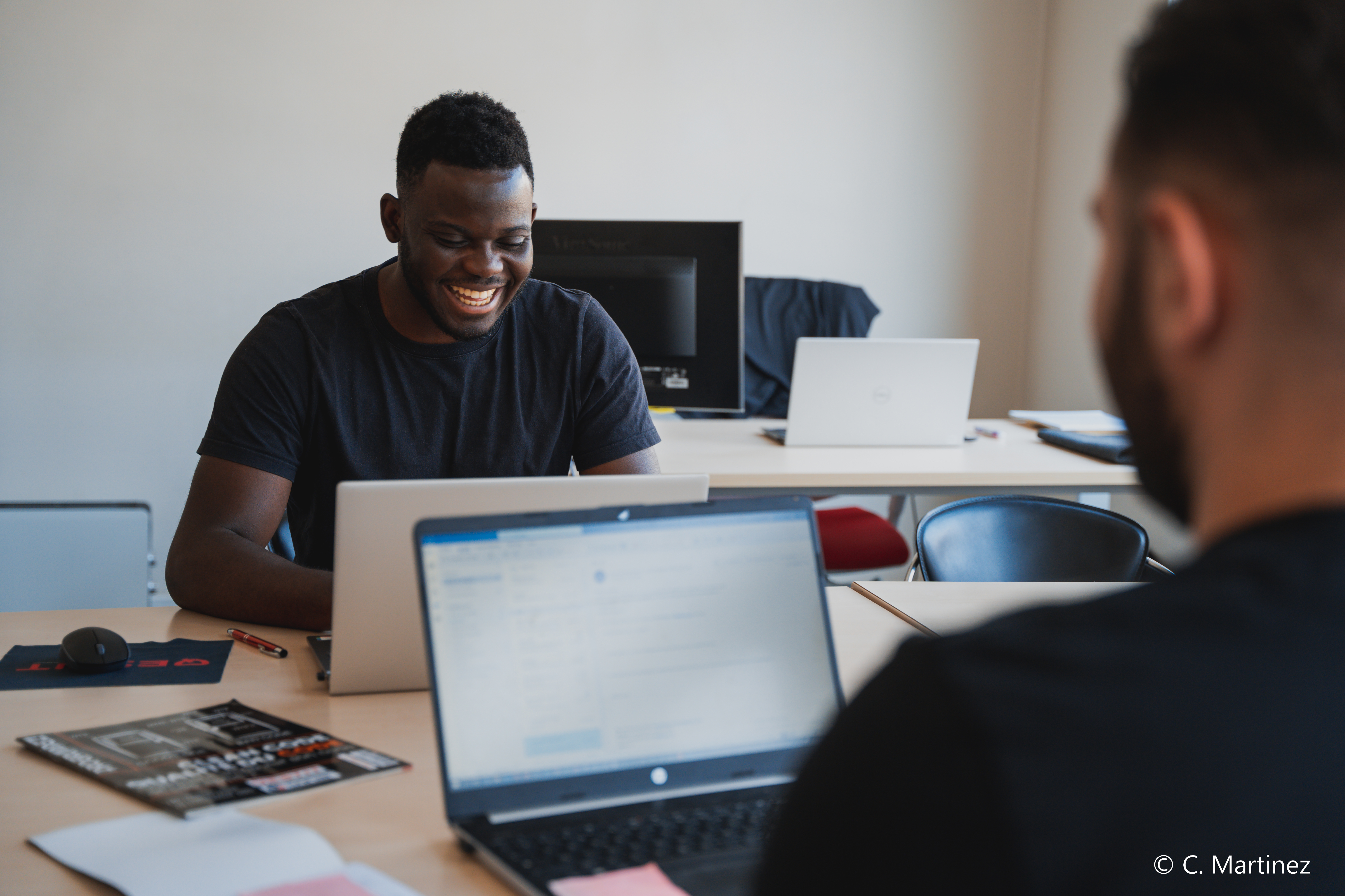 A collaborator working on his computer and smiling