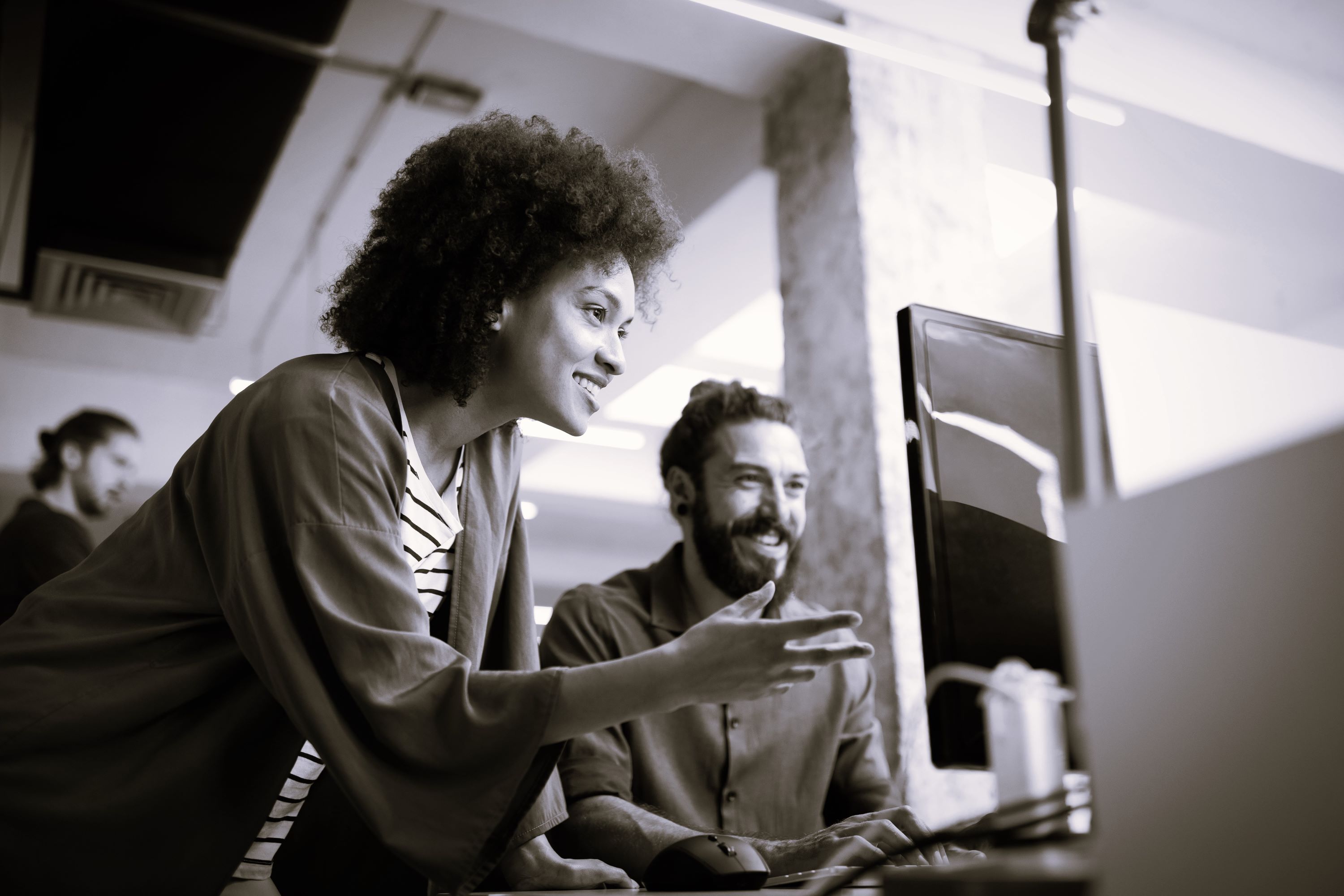 Woman and man talking in front of computer